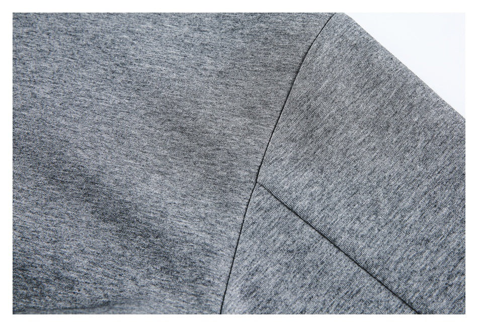 Close-up of a stitched shoulder or sleeve seam on a gray heathered garment.