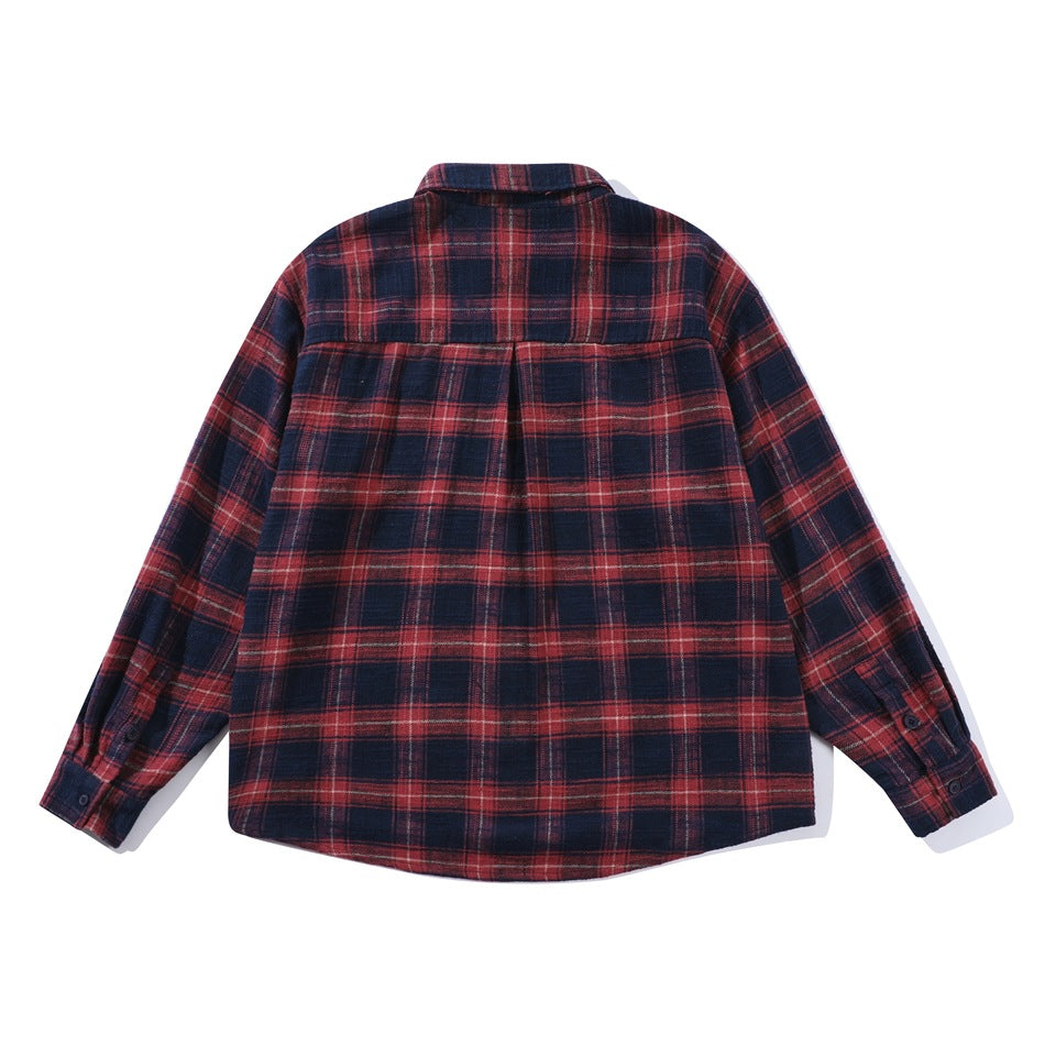Back view of red and navy plaid long-sleeve shirt showing yoke and center pleat, flat lay