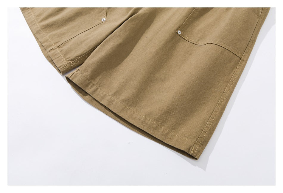 Close-up of the tan shorts legs, showing the hems and riveted pocket details.