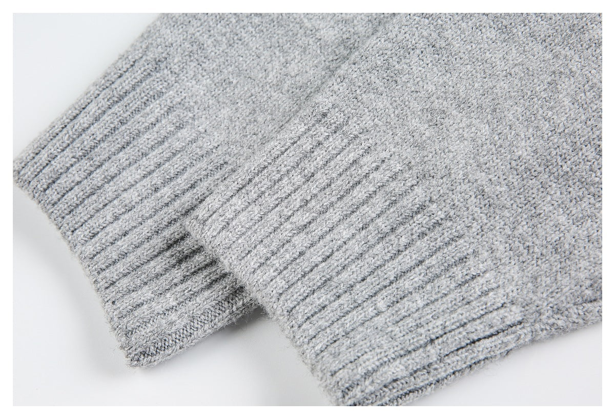 Light gray knit garment close-up showing ribbed edges and layered fabric folds.