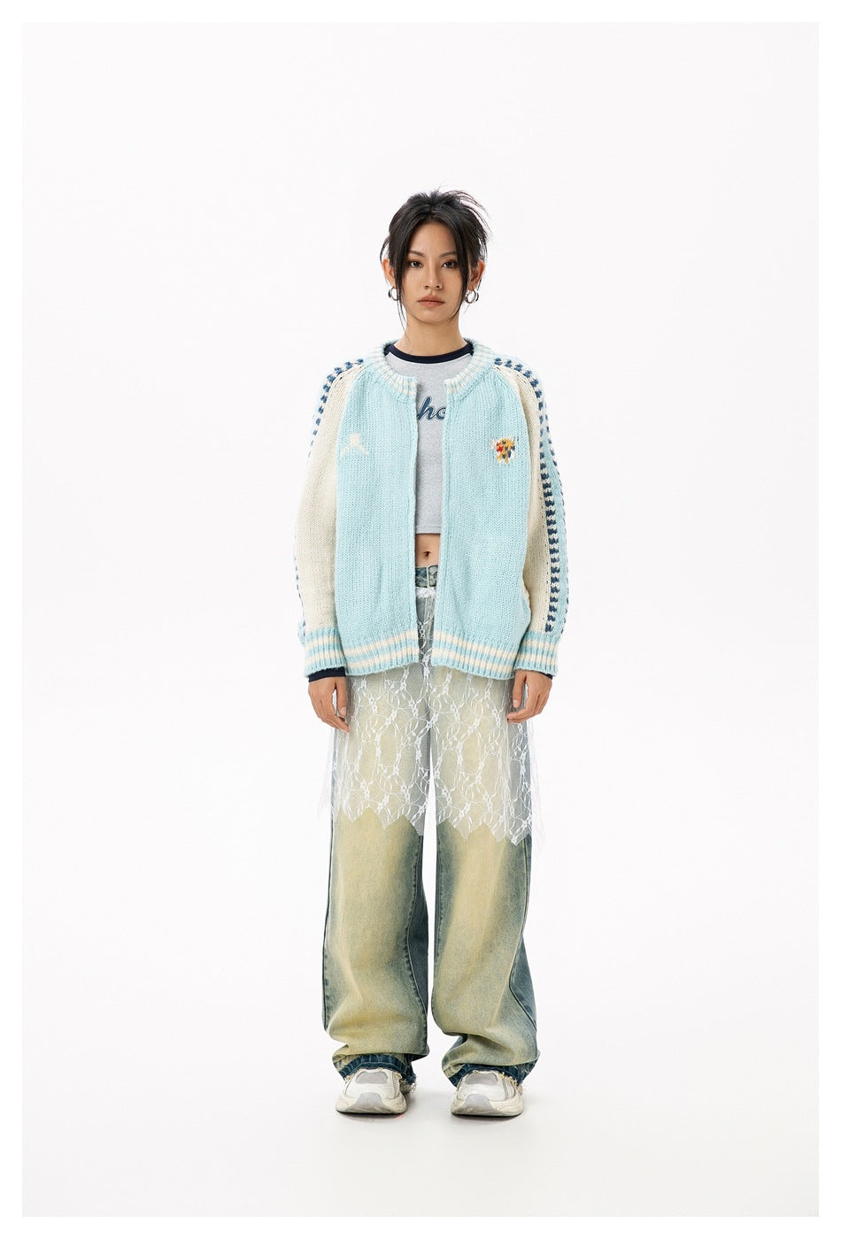 Model wearing the light blue knit zip cardigan open over a gray cropped tee with wide-leg faded jeans, front view