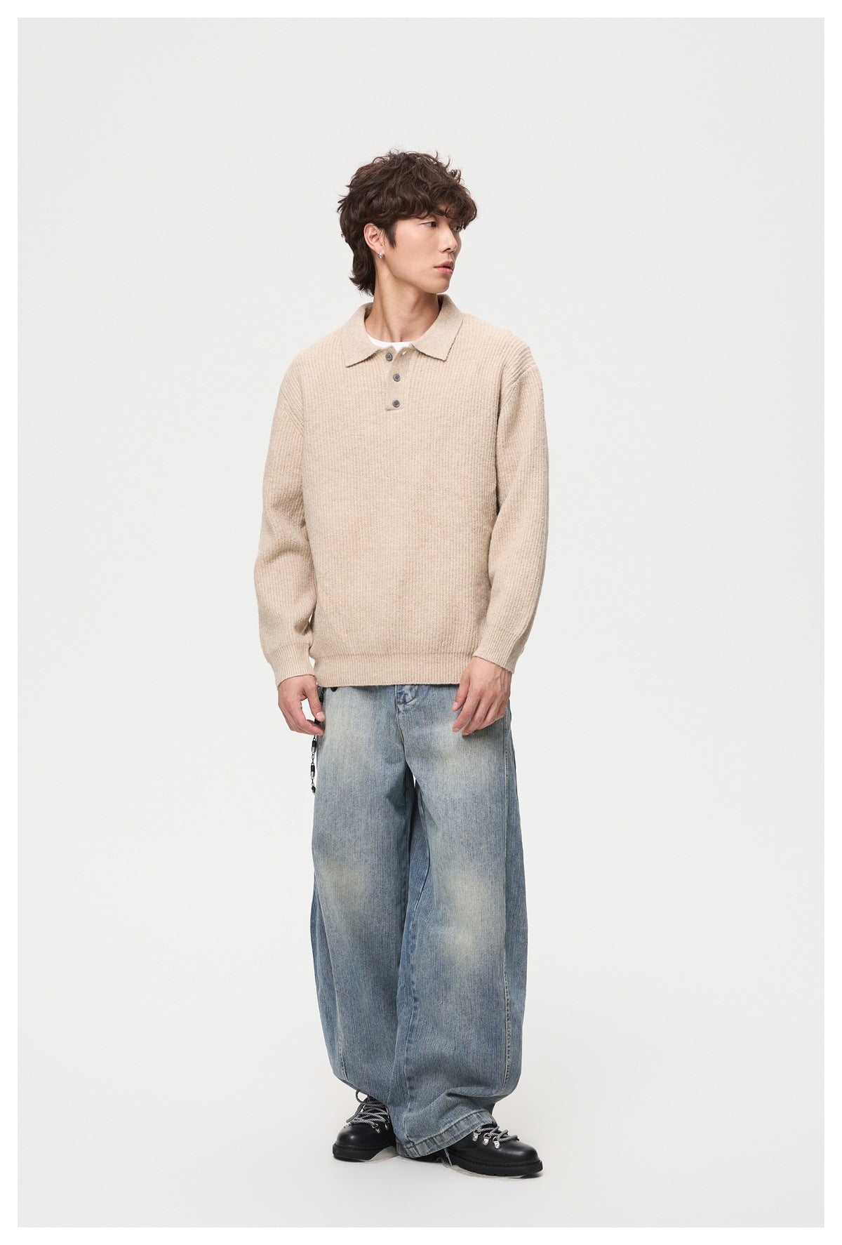 Model wearing a beige ribbed collared sweater with a three-button placket and loose light-wash jeans.