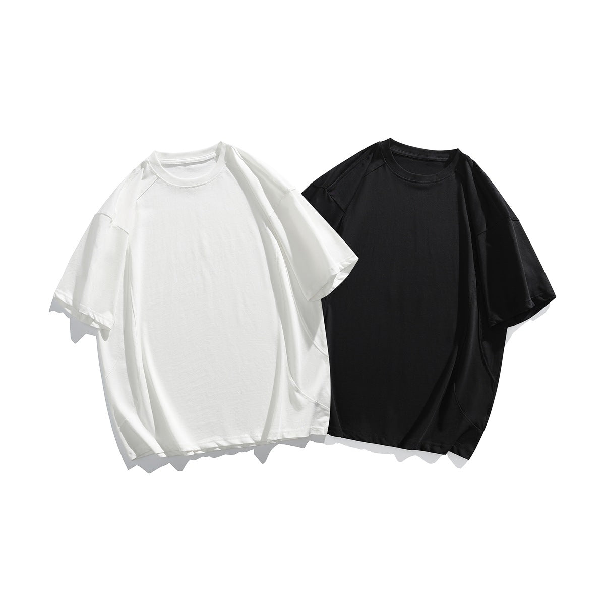 White and black oversized short-sleeve crew-neck T-shirts shown from the front.