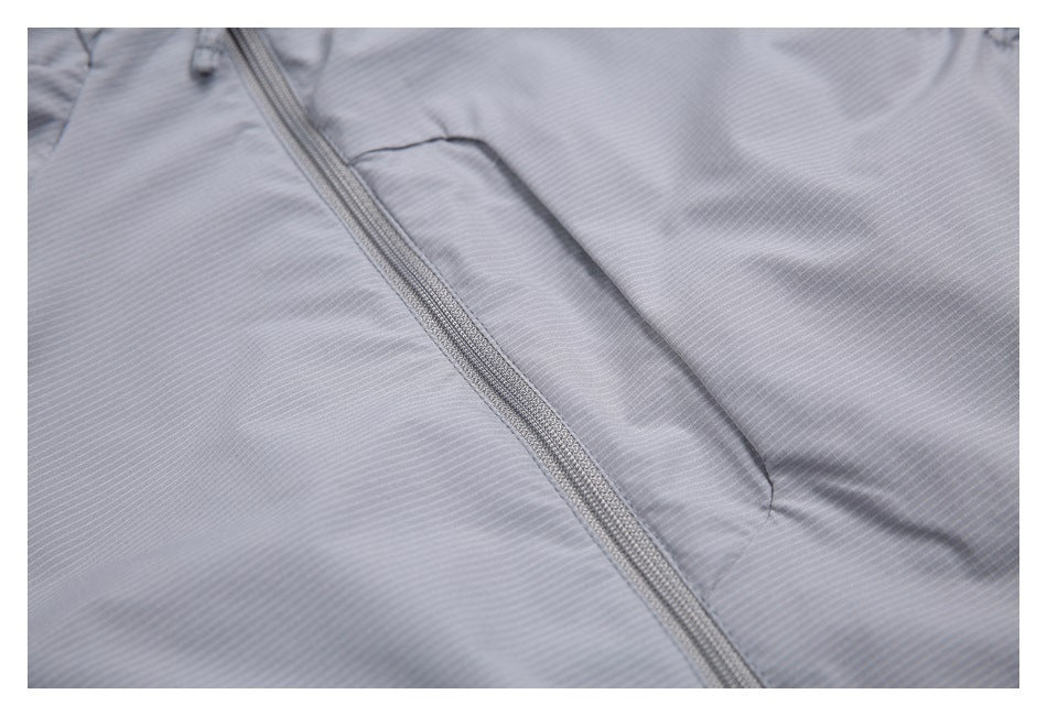Close-up of a gray garment's front zipper and a narrow pocket.