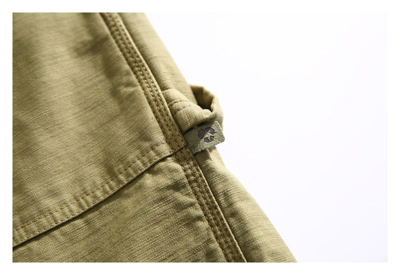 Close-up of a small fabric tab and stitched seam on khaki shorts.