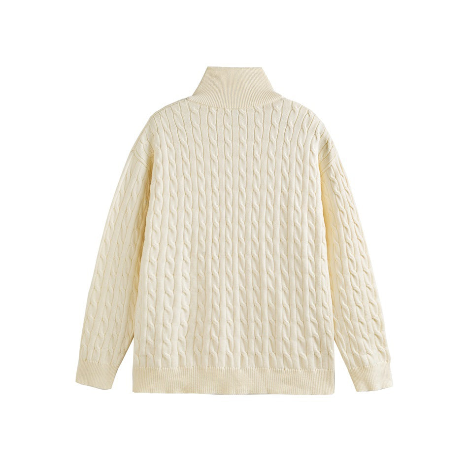 Back view of an ivory cable-knit sweater with a high collar and ribbed cuffs and hem.