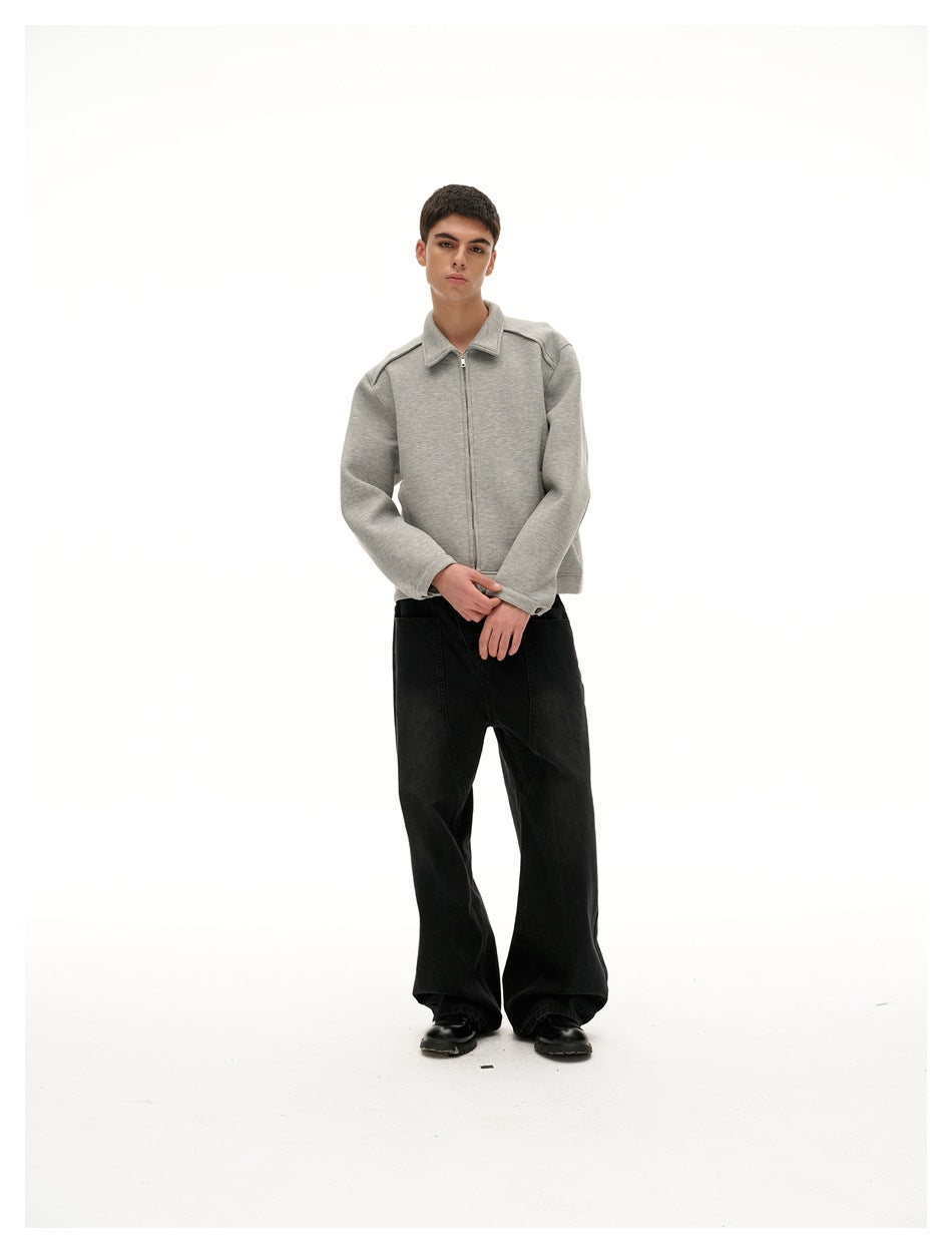 Full-length model in a light gray collared zip jacket and black wide-leg pants, standing with hands together.
