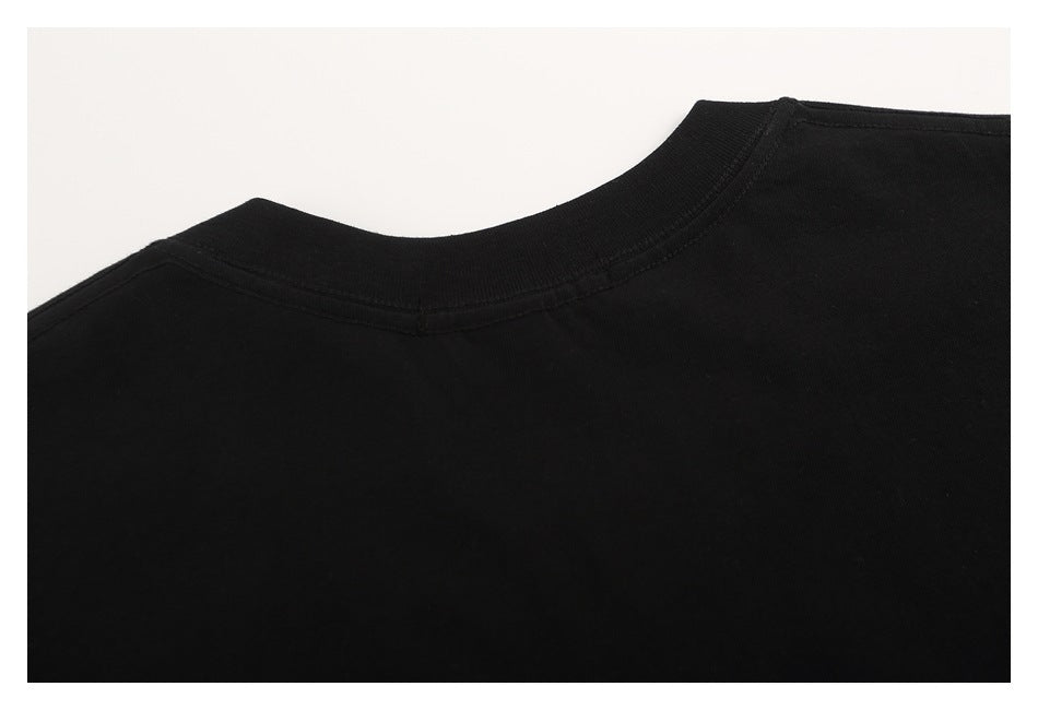 Close-up of a black crew-neck garment showing the ribbed neckline and shoulder seam.