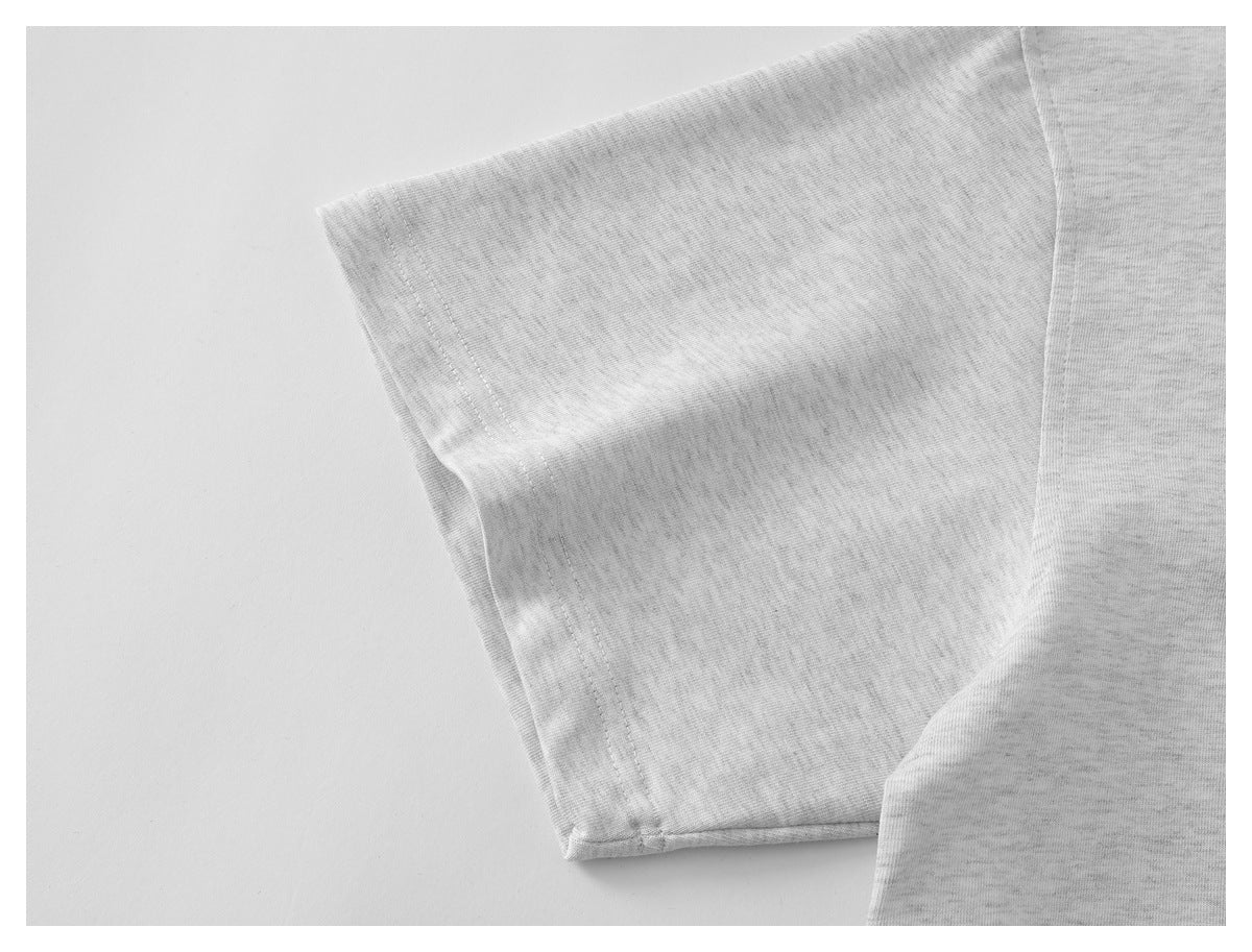 Close-up of a short sleeve and stitching on the light gray shirt.