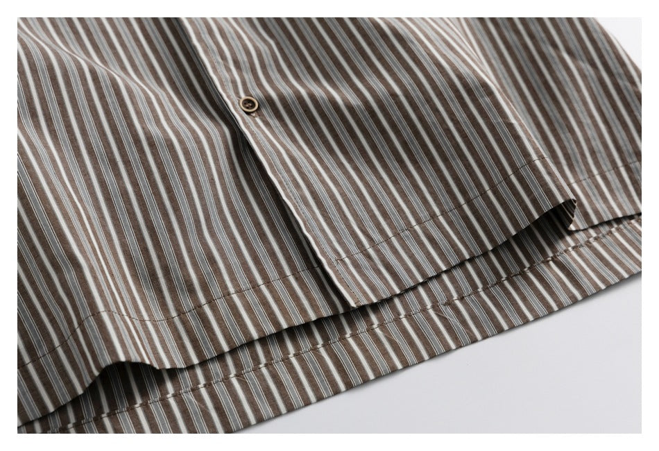 Close-up of a striped shirt's button placket and double-stitched hem.