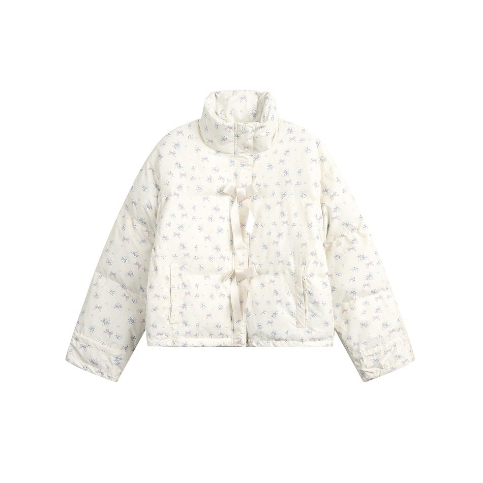 Cream quilted stand-collar jacket with a small floral and bow print and two ribbon bow ties at the front