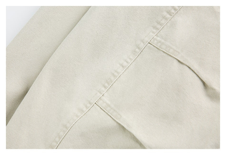Close-up of light beige garment panels and a stitched seam.