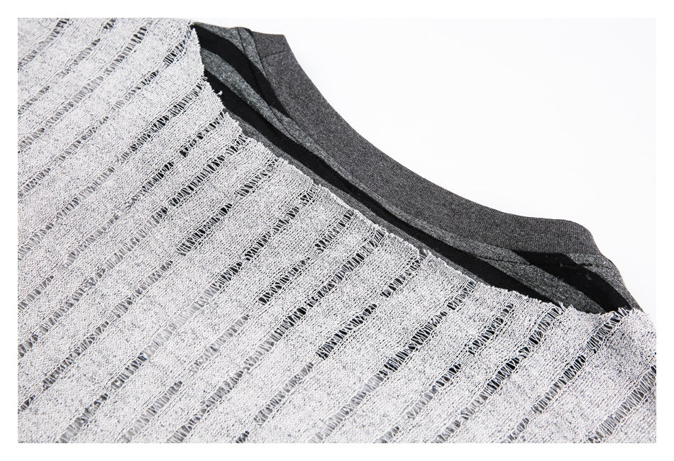 Inside view of striped knit fabric showing the reverse texture, seams, and dark gray neckline edge.