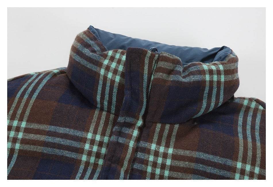 Close-up of a brown, navy, and aqua plaid jacket collar with dark blue lining and front closure.