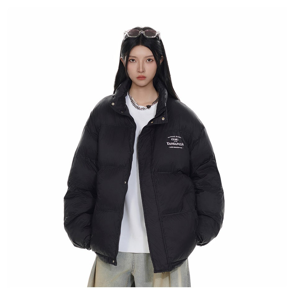 Front view of a model wearing an open black puffer jacket with a stand collar and small white chest lettering.