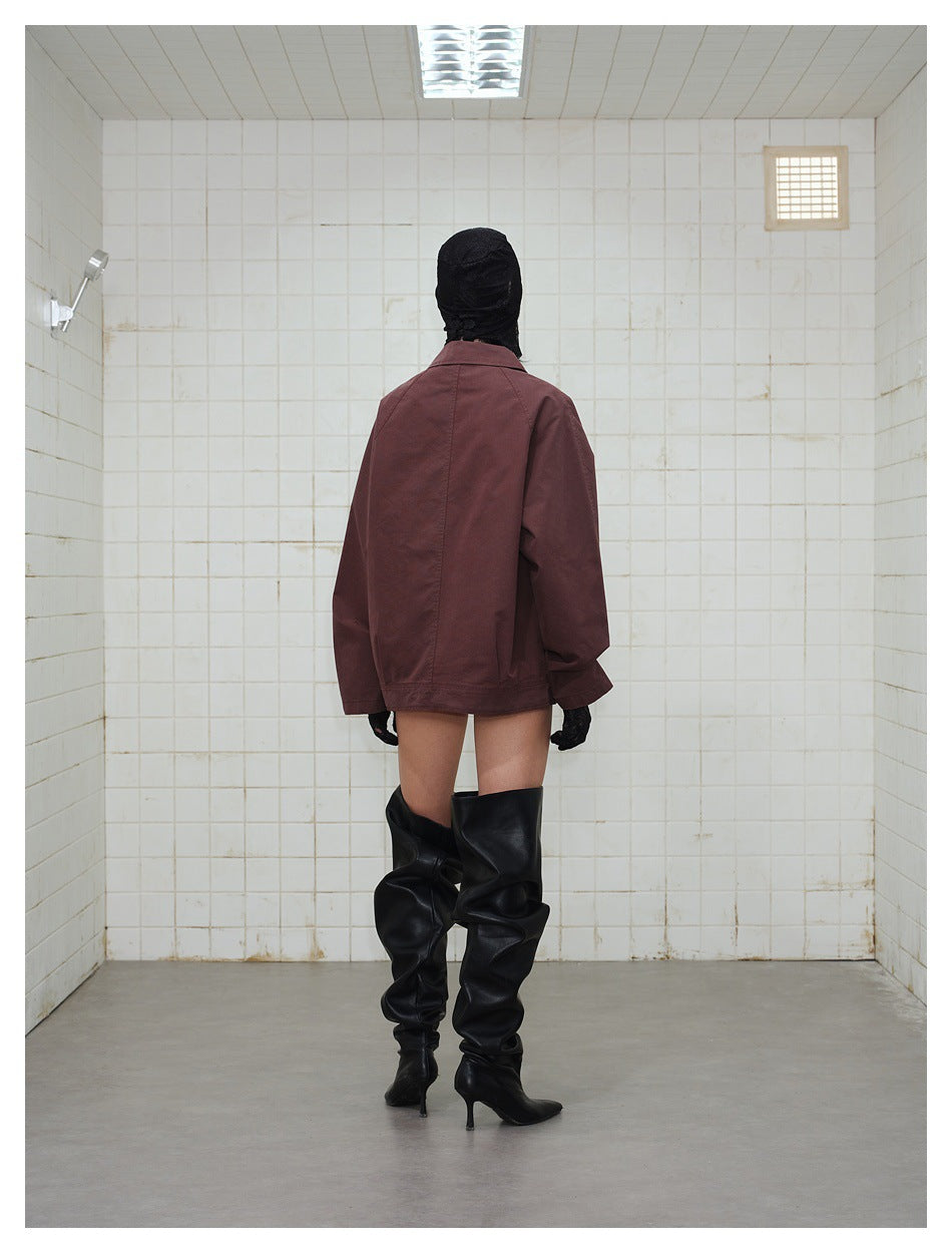 Back view of a model wearing a burgundy jacket with tall black boots.