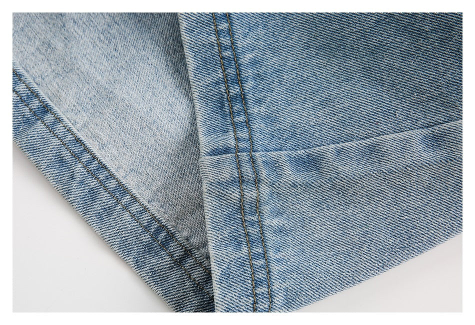 Close-up of folded light blue denim showing seams and a turned edge.