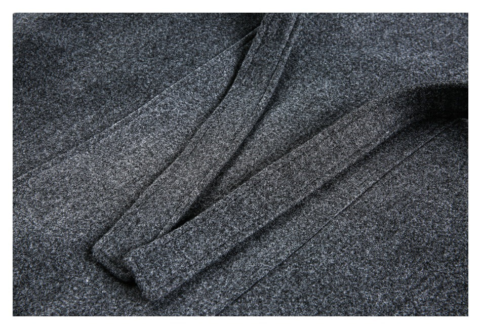 Close-up of overlapping edges and seams on a dark charcoal heathered garment.