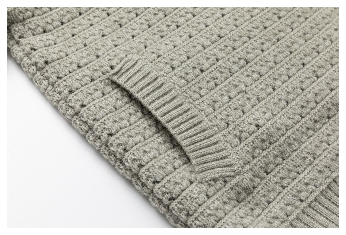 Close-up of the light gray cardigan's ribbed hem and textured knit pattern.