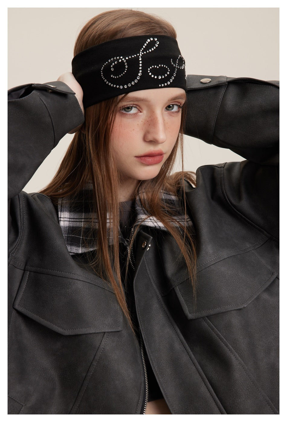 Close-up of a model wearing a charcoal jacket with a plaid collar, shoulder tabs and flap chest pockets.