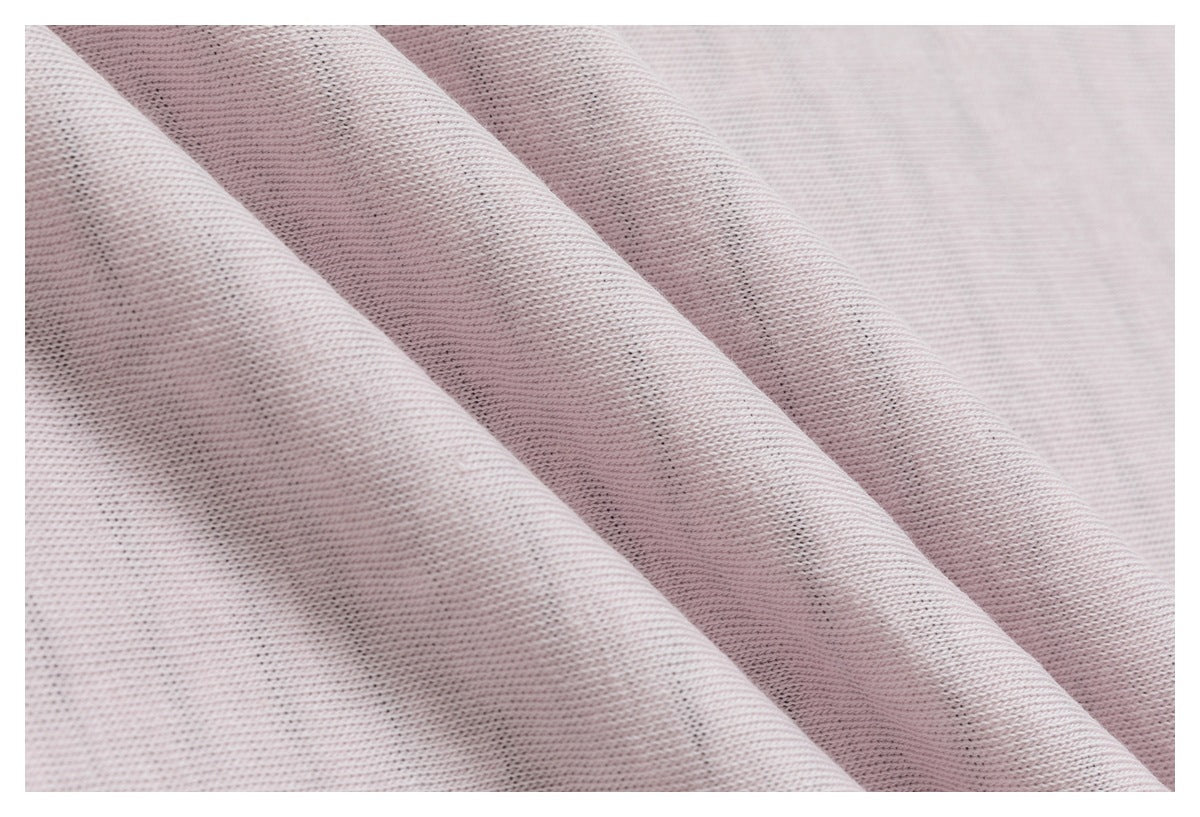 Pale blush fabric draped in soft folds, with its fine knit texture visible.