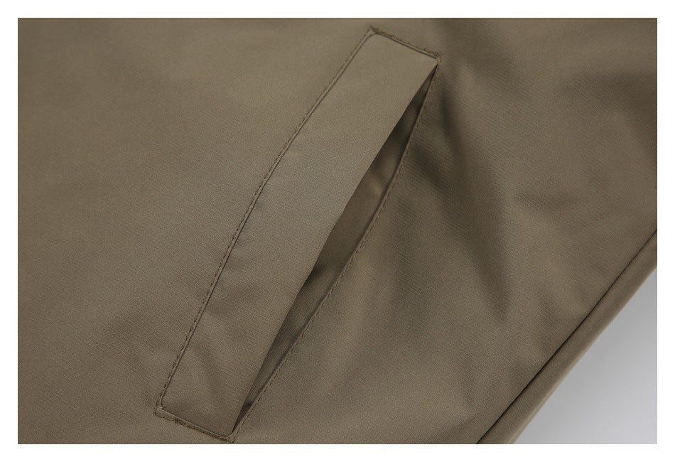 Close-up of a slanted welt pocket on an olive-brown garment.