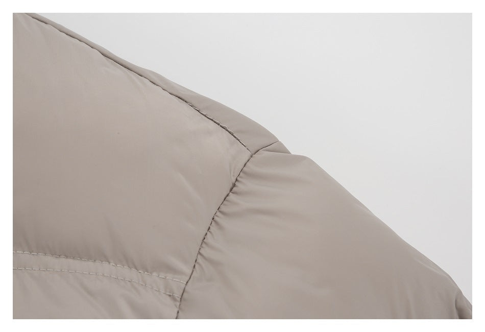 Close-up of the taupe jacket's shoulder seam and stitching.
