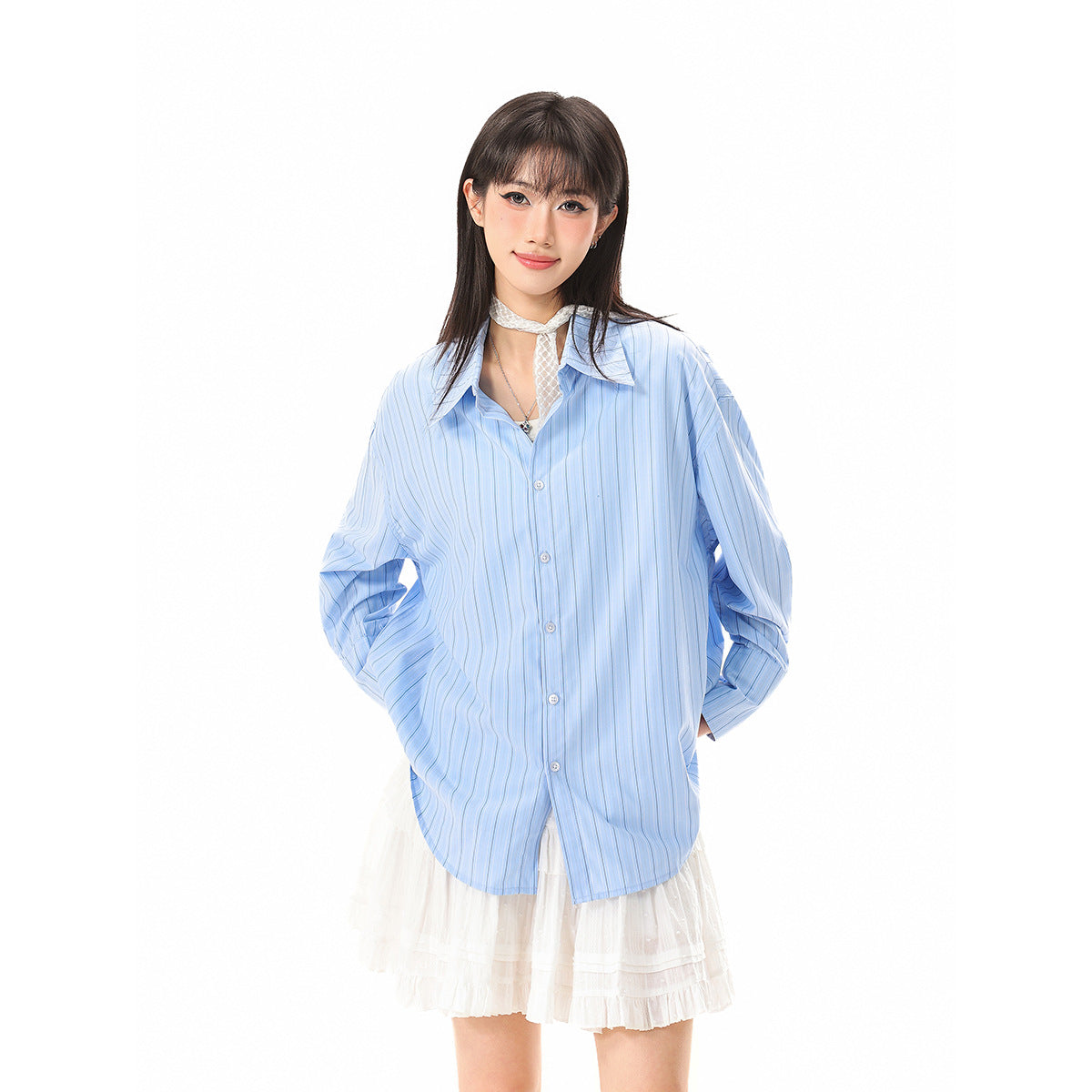 Model wearing an oversized light blue pinstriped button-up shirt with a pointed collar.