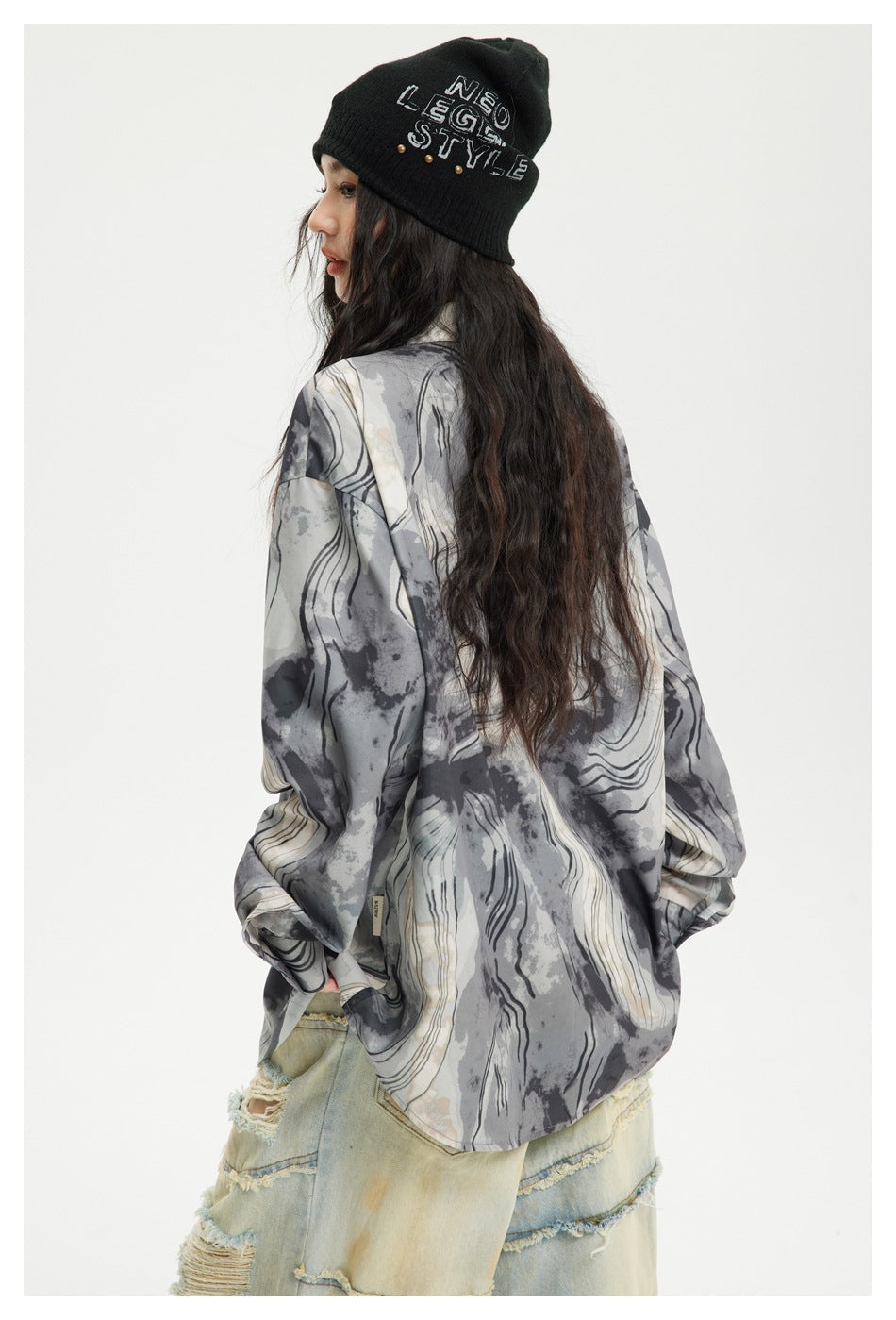 Model in a loose gray, black, and ivory abstract-print shirt, shown from the side and back.