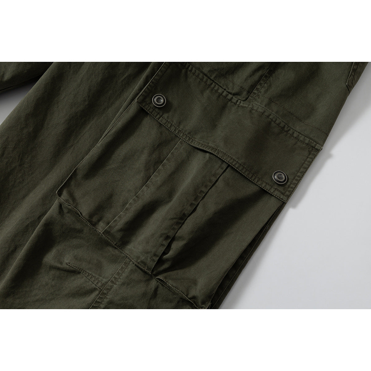 Close-up of an olive cargo pocket with a buttoned flap and stitched panel details.
