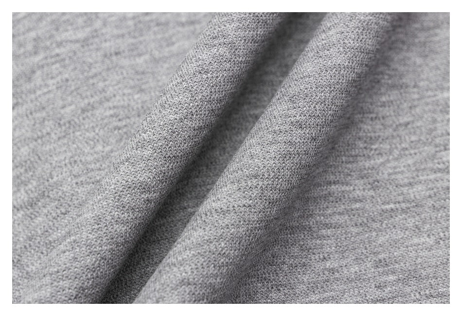 Close-up showing the soft-looking, heather-gray knit texture draped into folds.