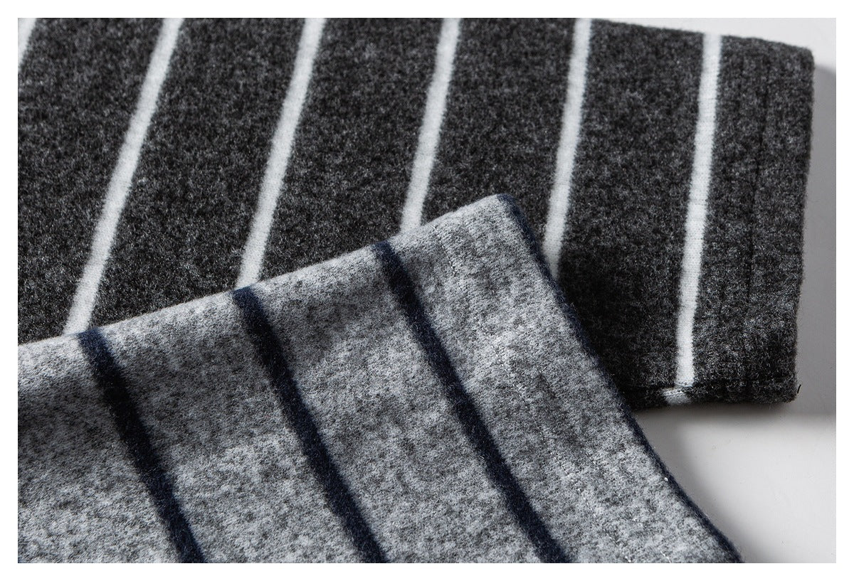 Close-up of folded charcoal and gray striped fabric showing the knit surface and contrasting stripe pattern.