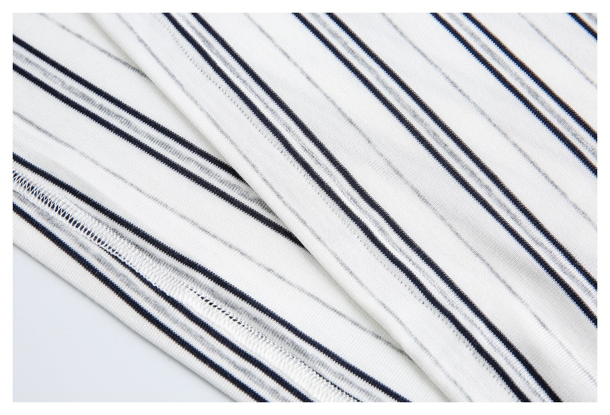 Close-up of the white polo shirt's striped fabric and neatly stitched hem.