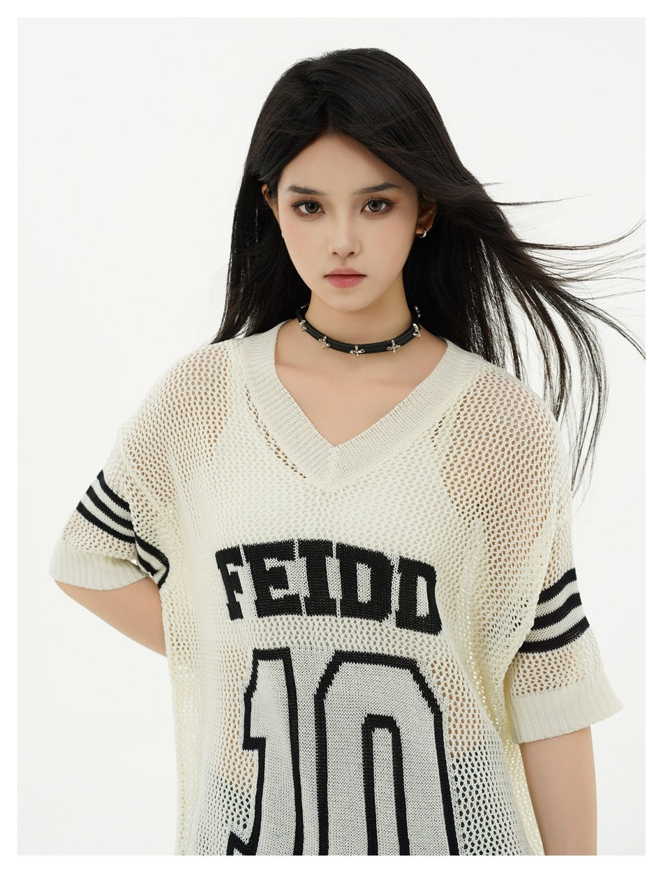 Model wearing an off-white open-knit V-neck top with striped sleeves and a black FEIDD 10 graphic, close crop