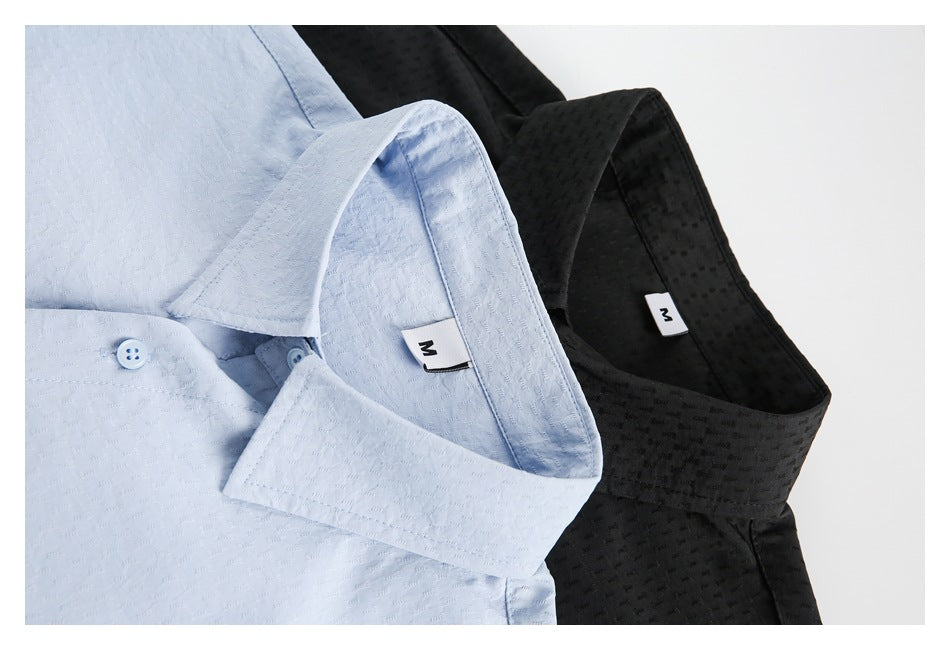 Close-up of light blue and black shirts showing pointed collars, subtle woven texture, and M size labels.