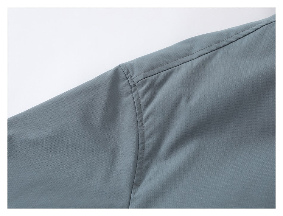 Close-up of a gray jacket shoulder seam and sleeve on a white background.