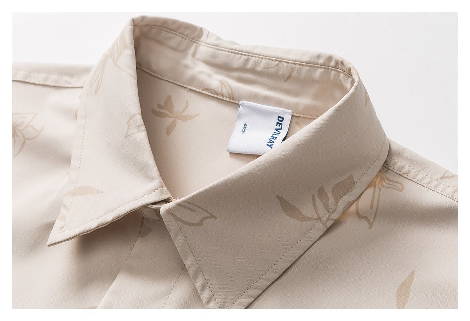 Close-up of the pointed collar and sewn-in label on a beige floral shirt.