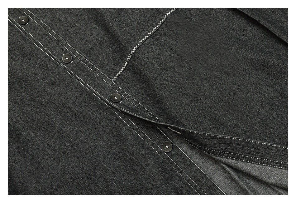 Close-up of a charcoal shirt's button placket and overlapping fabric with contrasting white stitching.