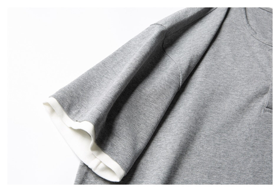 Close-up of a heather-gray sleeve with a white ribbed cuff on a shirt.