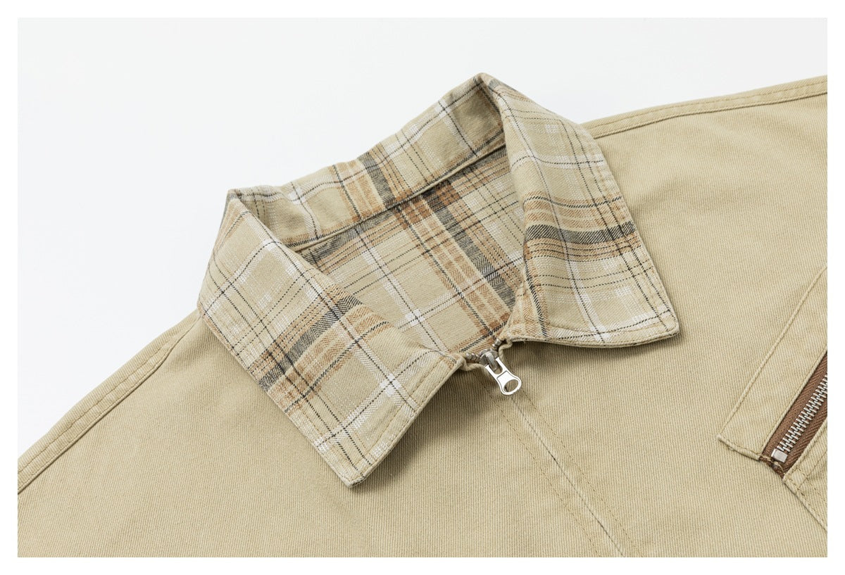 Close-up of the jacket's beige plaid collar, front zipper pull, and sand-colored fabric.