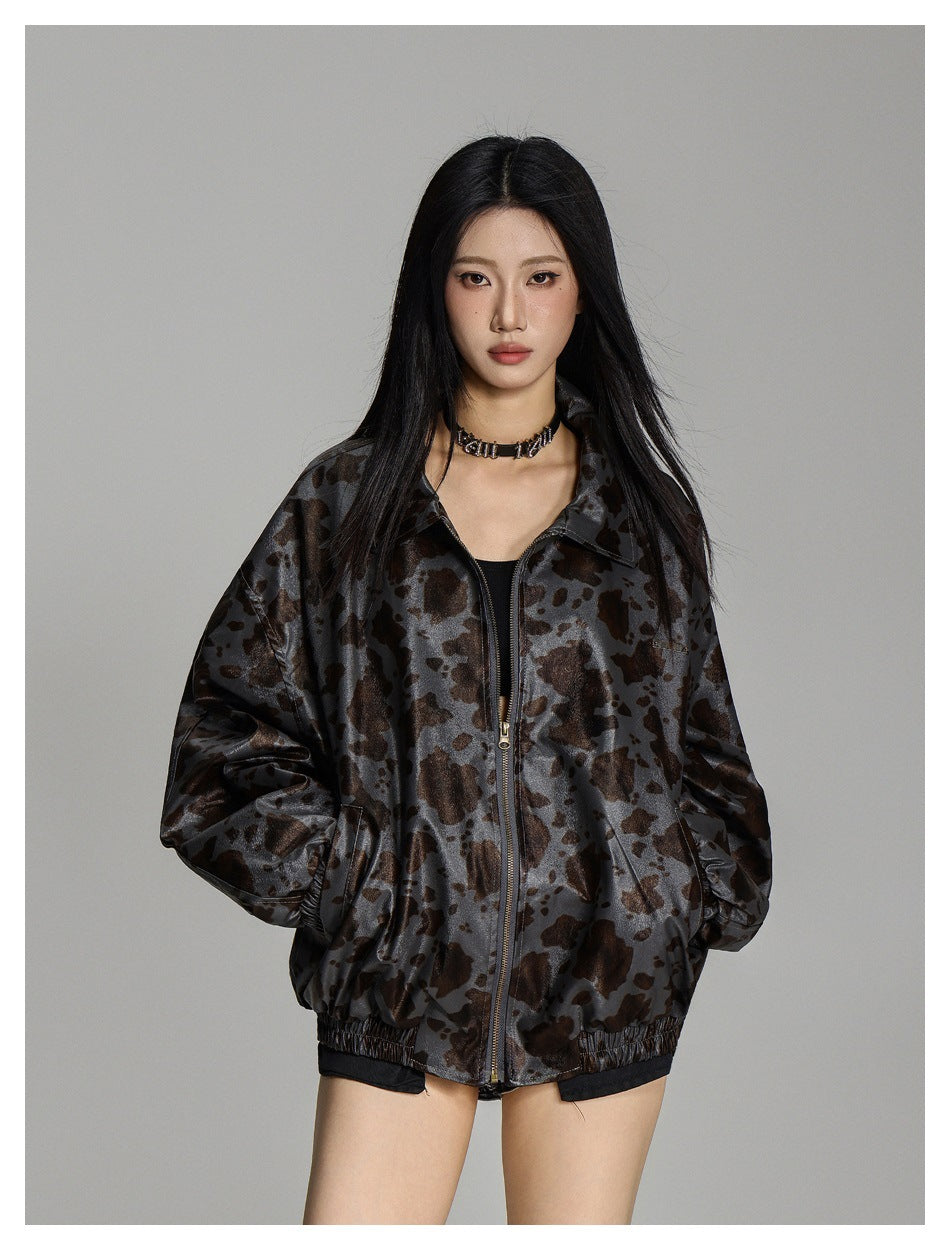 Front view of a model wearing an oversized gray-brown spotted zip jacket with a pointed collar and elastic hem.
