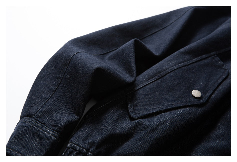 Close-up of the dark indigo jacket sleeve and snap-button flap pocket.