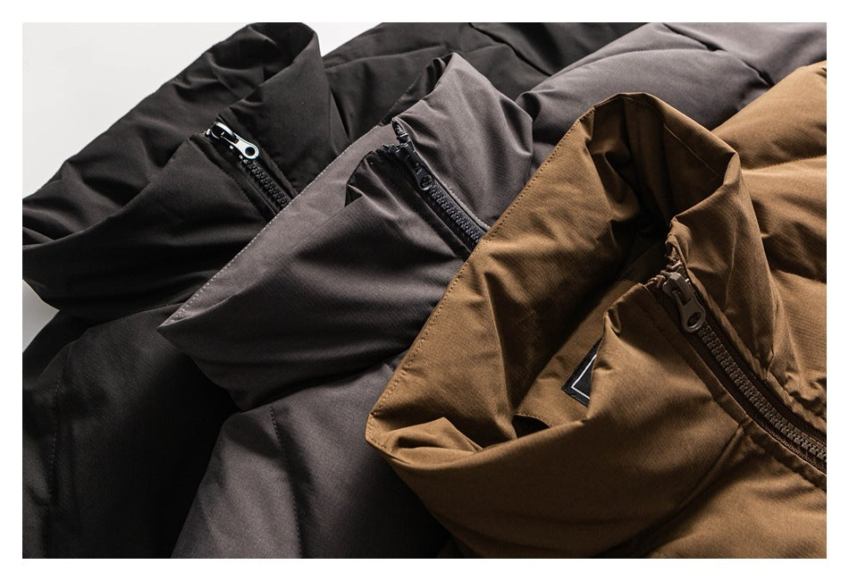 Close-up of black, charcoal gray, and brown jackets arranged together, showing their zippers and collars.
