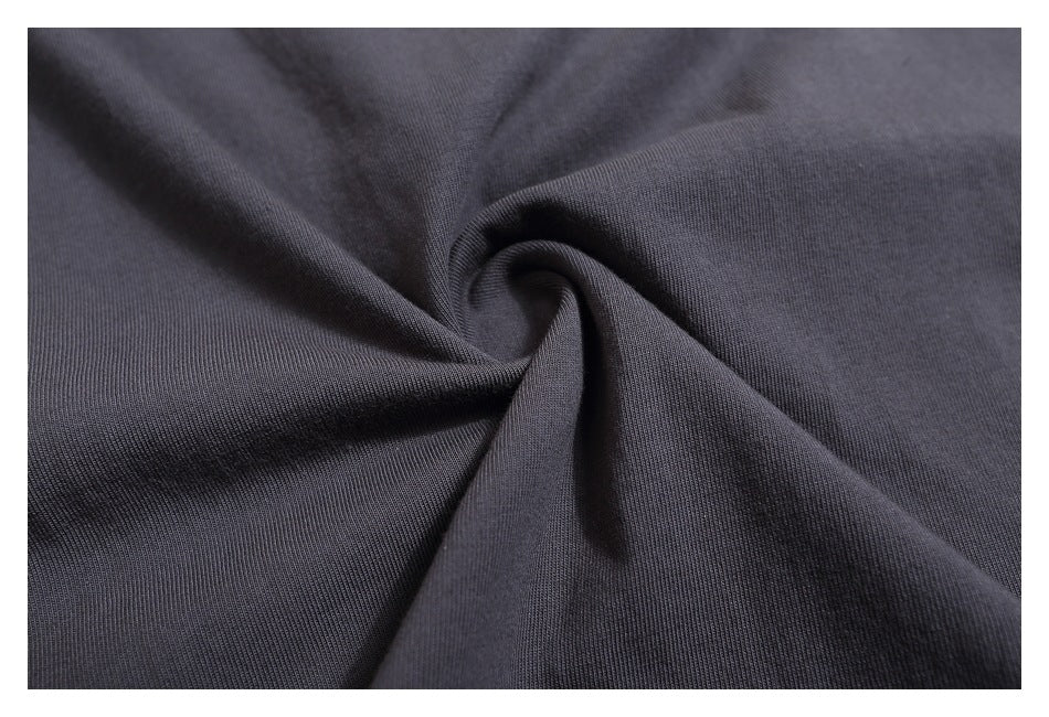 Close-up of dark charcoal fabric gathered into a twist, showing a fine ribbed texture.