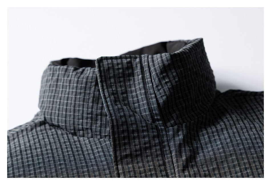 Close-up of a charcoal plaid garment's structured stand collar and upper edge.