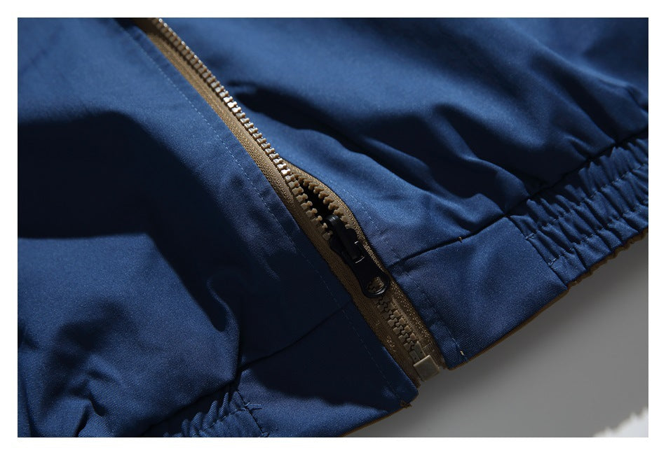 Close-up of a brown zipper beside the gathered elastic edge of a navy garment.