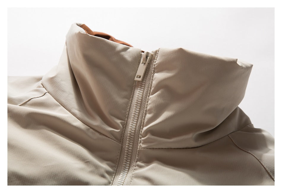 Close-up of a beige garment’s raised collar and front zipper.