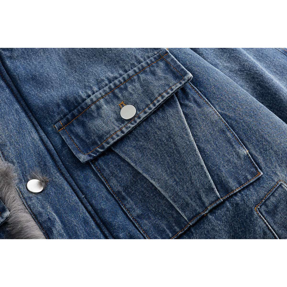 Close-up of a flap pocket and silver snap on blue denim, with gray faux fur visible at the edge.