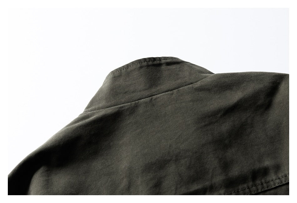 Close-up of the dark olive jacket's collar and shoulder seam.
