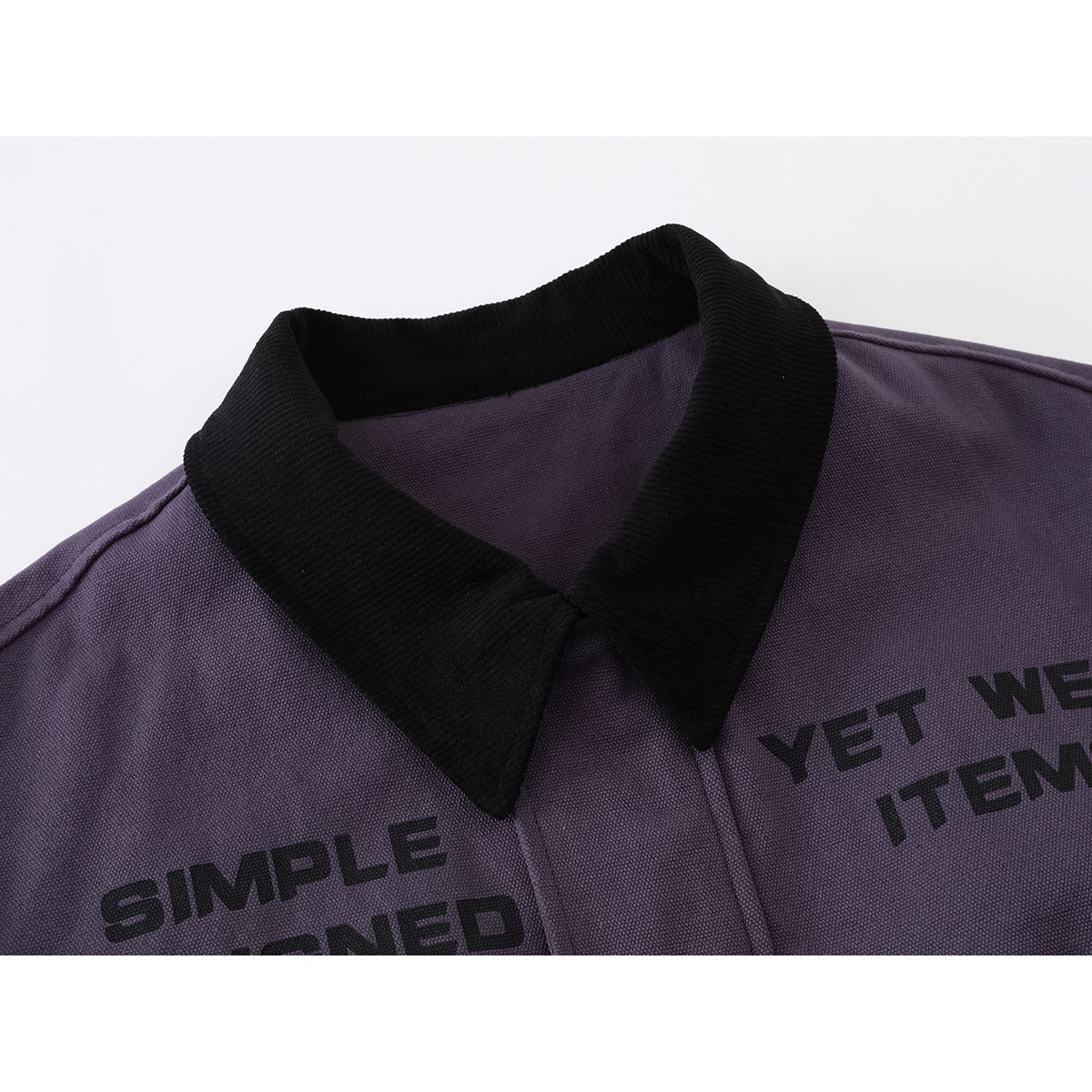 Close-up of a purple jacket's black ribbed collar and partial black lettering printed on the chest.